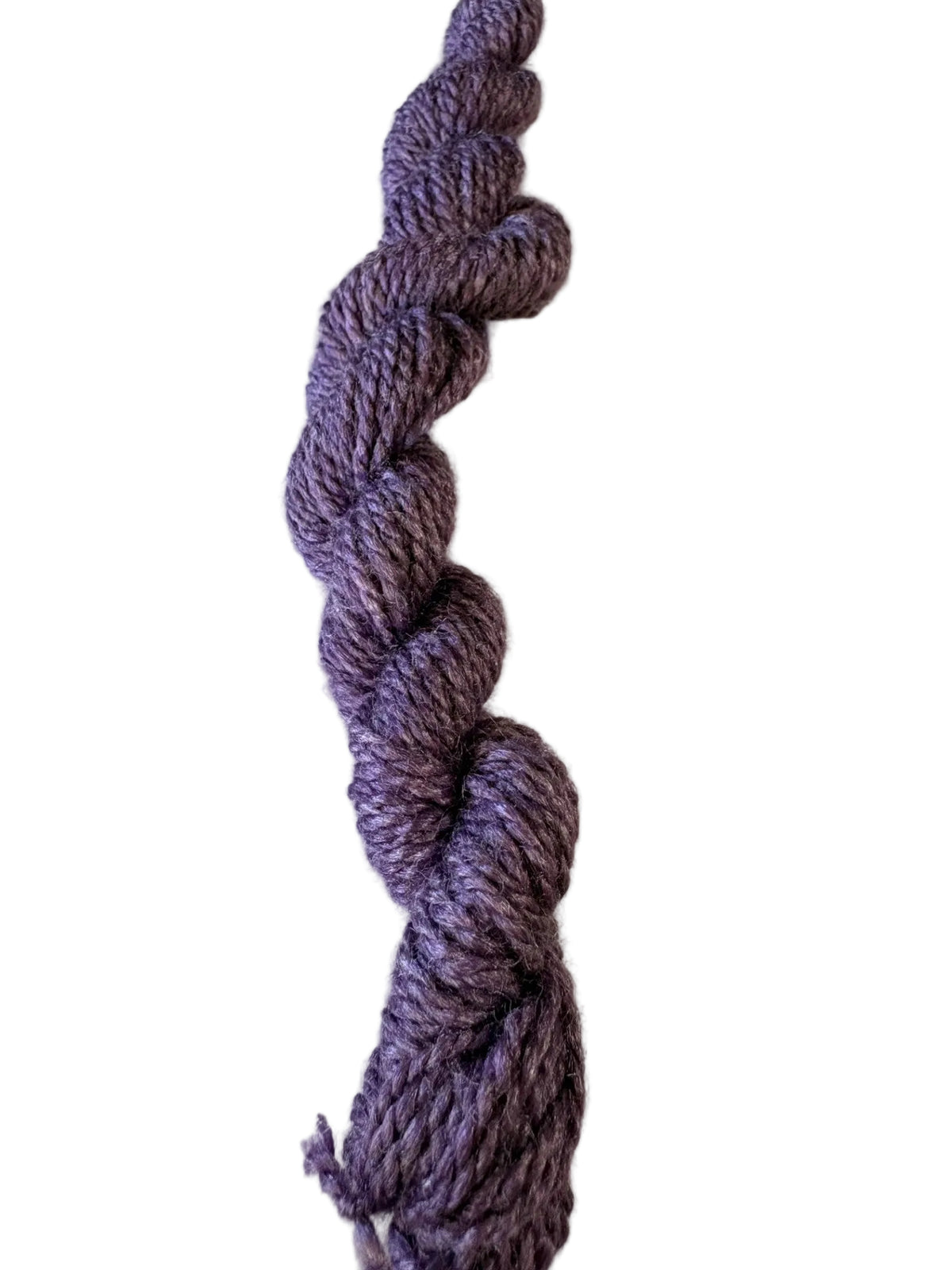 A single twisted skein of heathered purple yarn standing vertically against a plain off-white background.