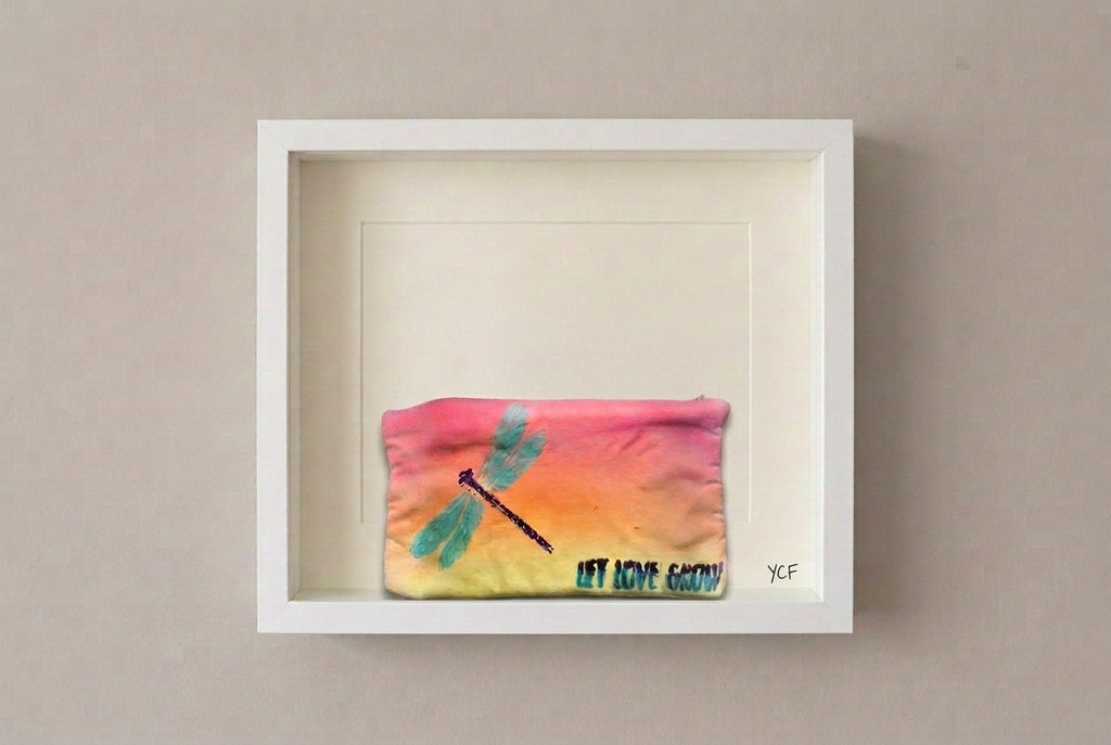 A rectangular fabric pouch with a yellow-to-orange gradient, featuring a painted teal dragonfly and the text 'LET LOVE GROW' in teal and black.