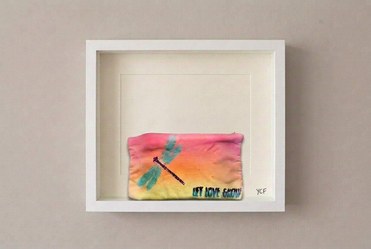 A rectangular fabric pouch with a yellow-to-orange gradient, featuring a painted teal dragonfly and the text 'LET LOVE GROW' in teal and black.