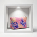 A rectangular pink and peach fabric item with a blue and purple butterfly and floral print, photographed flat against a light background.