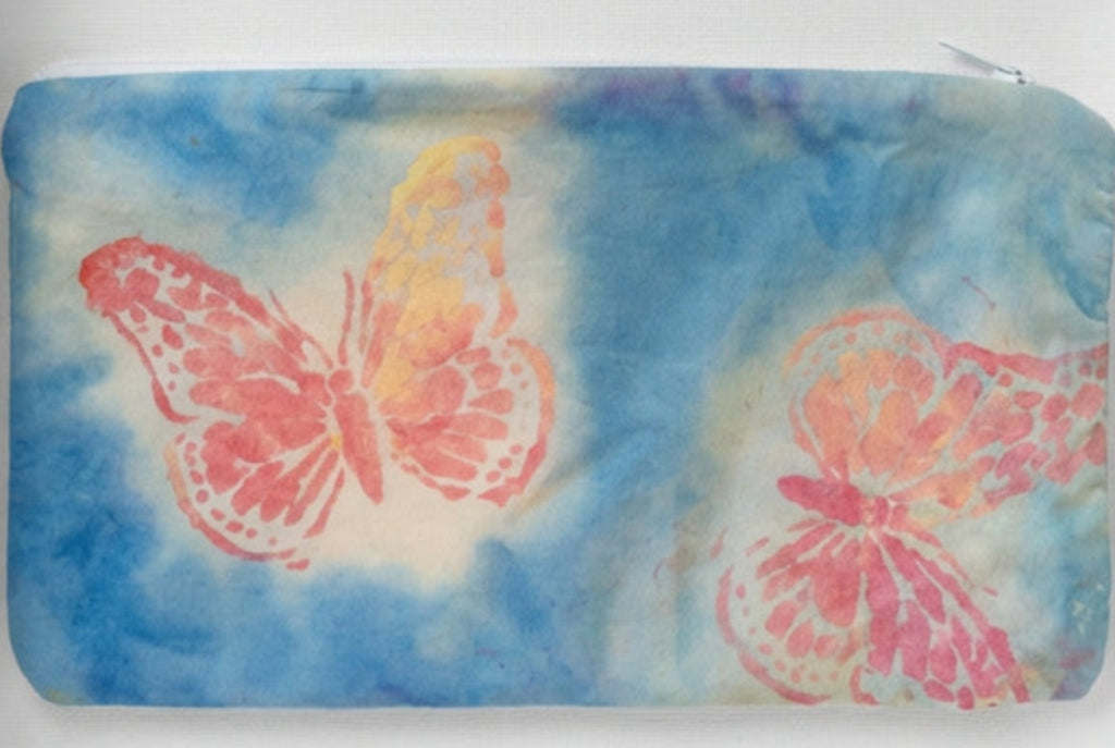 A rectangular fabric pouch or sleeve with a blue-gray background and two large butterfly prints in pink, orange, and yellow.