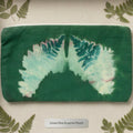 A green fabric pouch or clutch with a printed fern leaf design in shades of green, teal, and pale yellow.