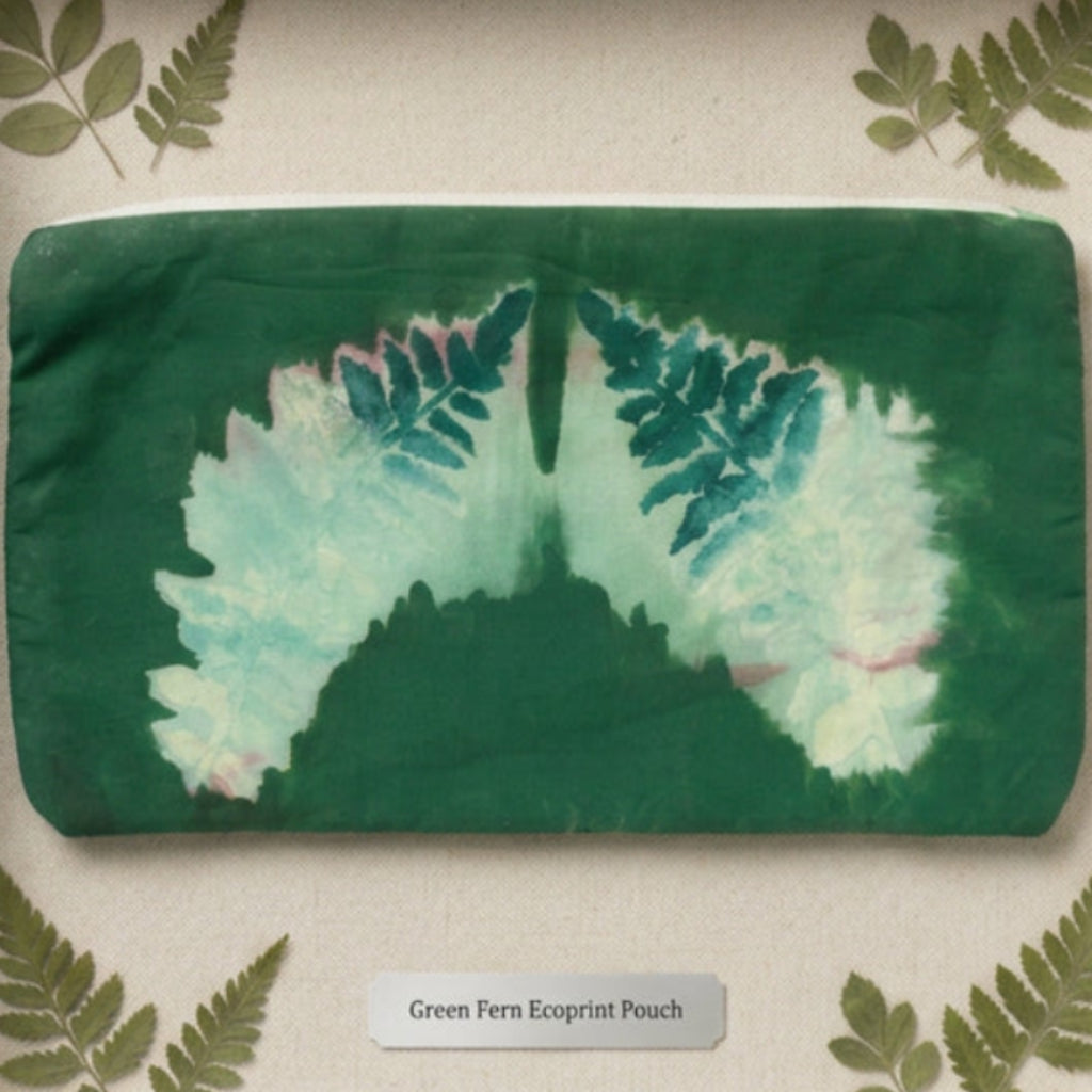 A green fabric pouch or clutch with a printed fern leaf design in shades of green, teal, and pale yellow.