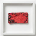 A red fabric pouch with a black floral pattern.