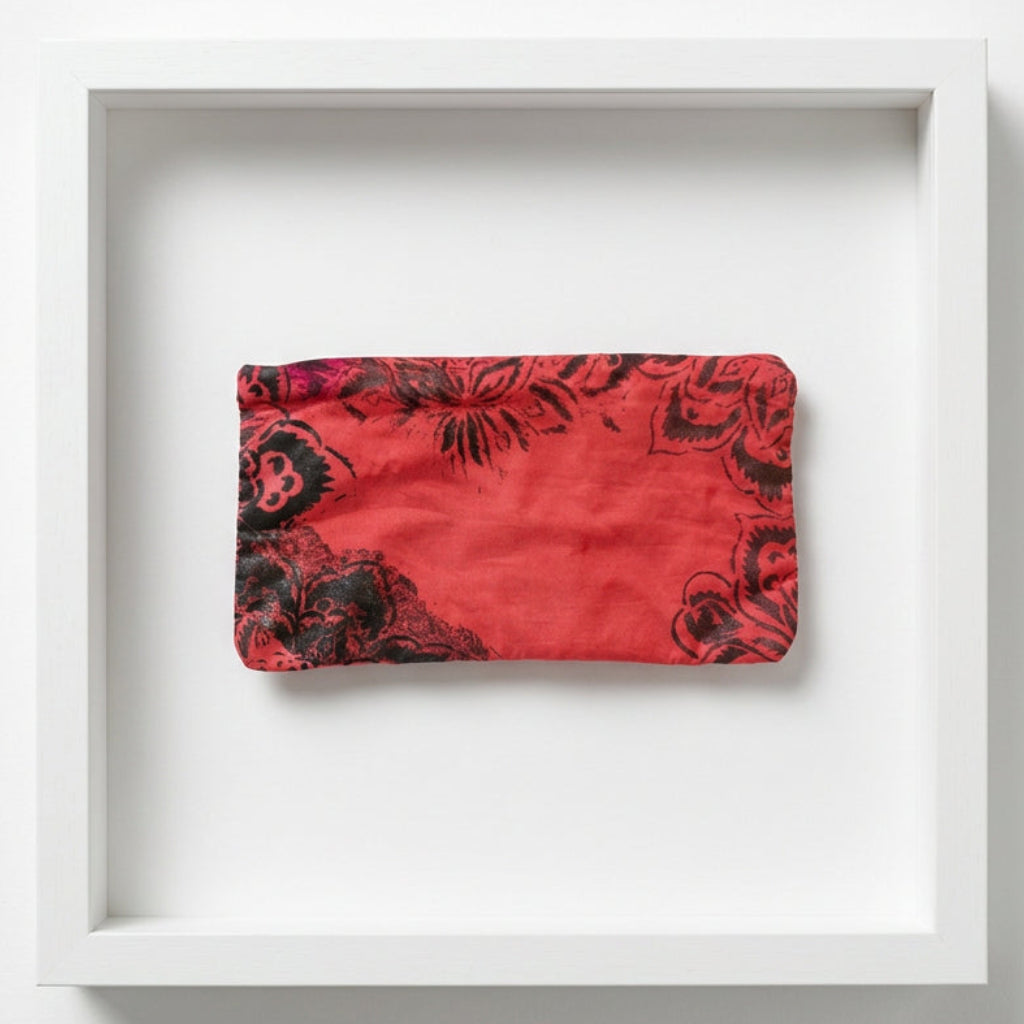 A red fabric pouch with a black floral pattern.
