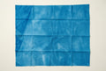 A blue fabric backdrop sheet with visible vertical creases.