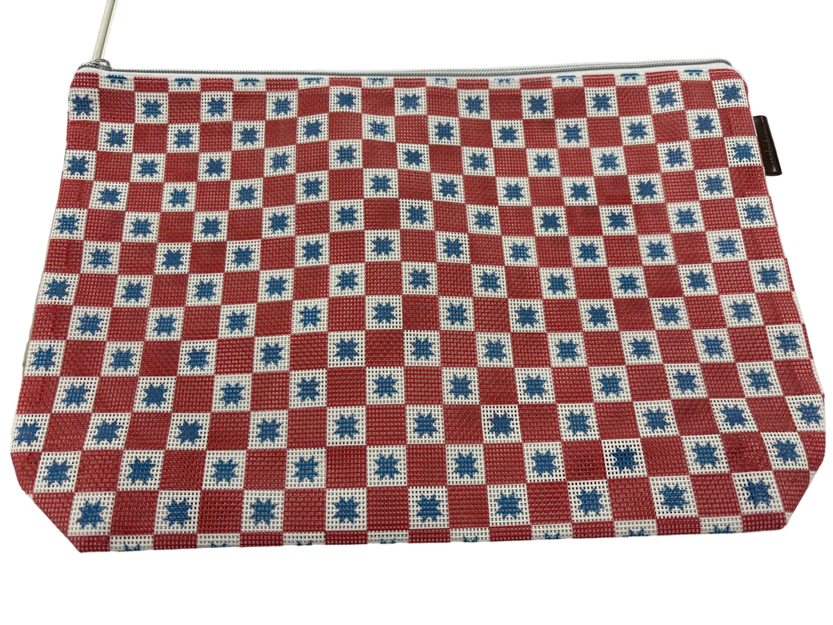 A rectangular woven textile item, likely a pouch or cover, featuring a red, white, and blue star pattern. The fabric has a visible basketweave texture and is shown hanging against a plain white wall.